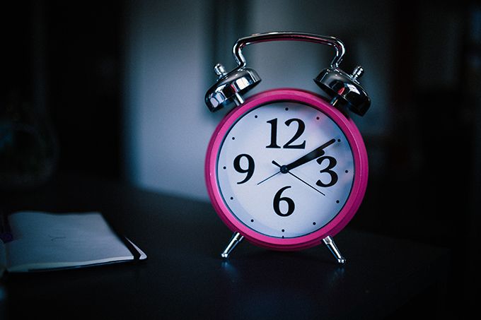 Pink alarm clock on a table.
