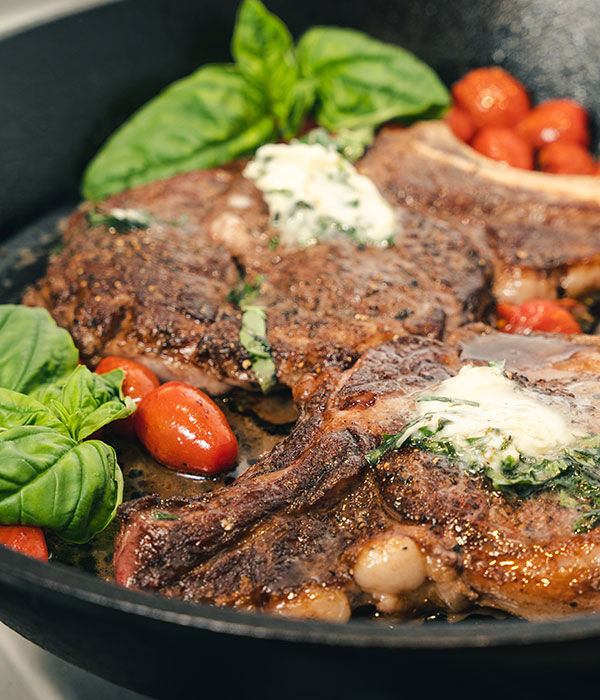 Basil Butter Ribeye Steaks with Charred Cherry Tomatoes