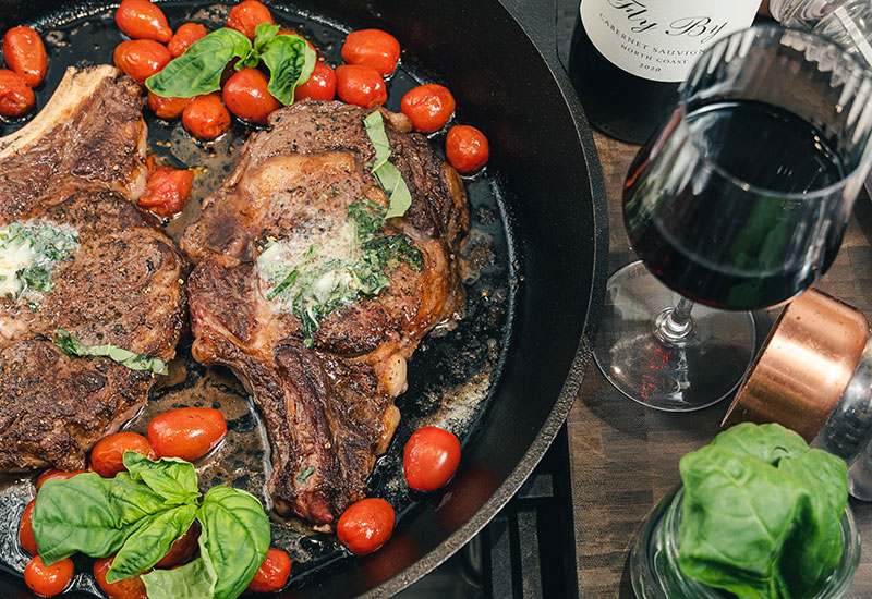 Basil Butter Ribeye Steaks with Charred Cherry Tomatoes