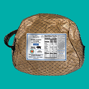 Heinen's packaged spiral ham in a gold wrapping with black netting.