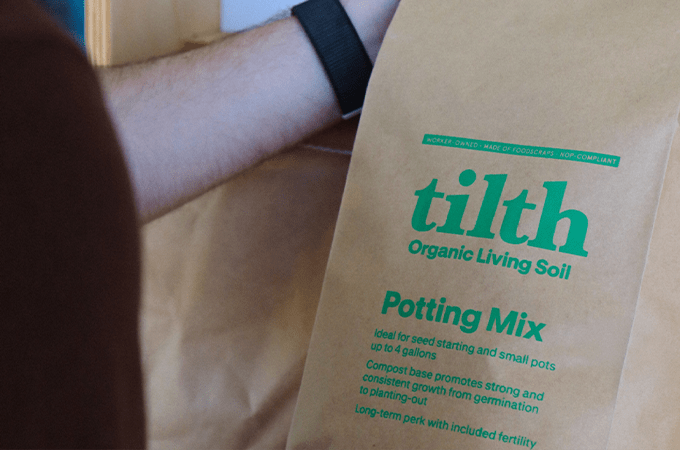 someone holding a bag of tith soil