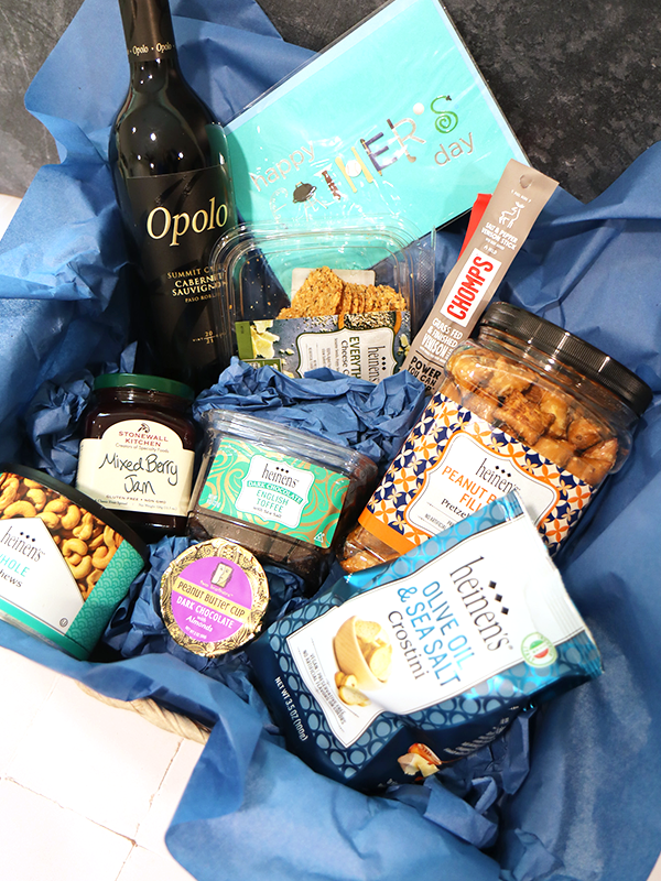 Father's Day gift basket with chocolate, beef sticks, cashews, cheese crips, jam, peanut butter pretzel nuggets, and peanut butter cups.