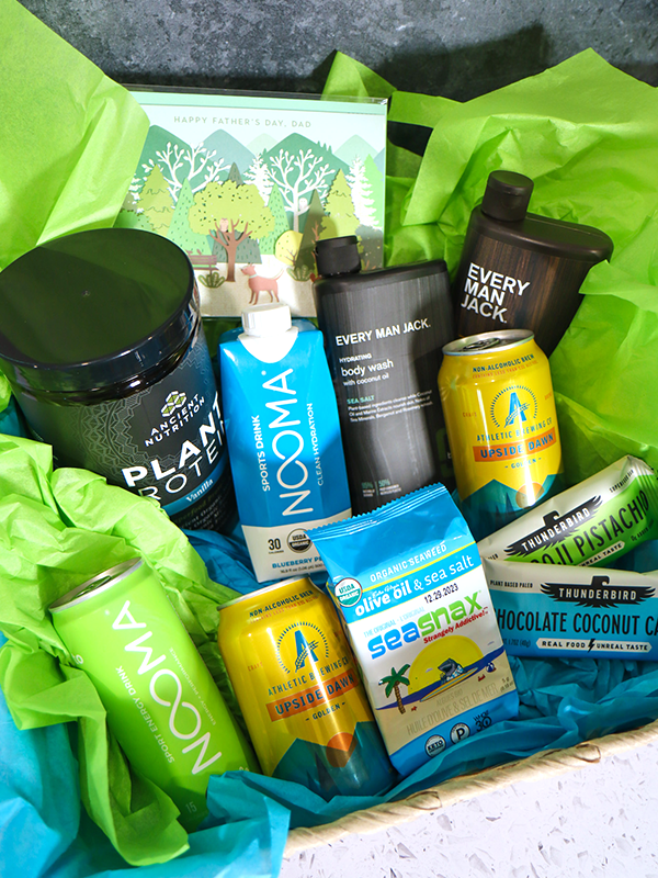 Father's Day gift basket with body wash, protein powder, electrolyte and energy drinks, nutrition bars, and non-alcoholic beer.