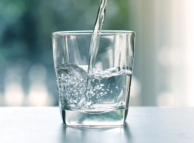 a glass of water being poured