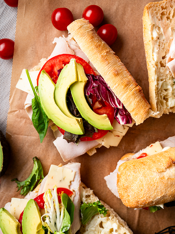 Roasted Turkey Sandwich topped with tomato and avocado.