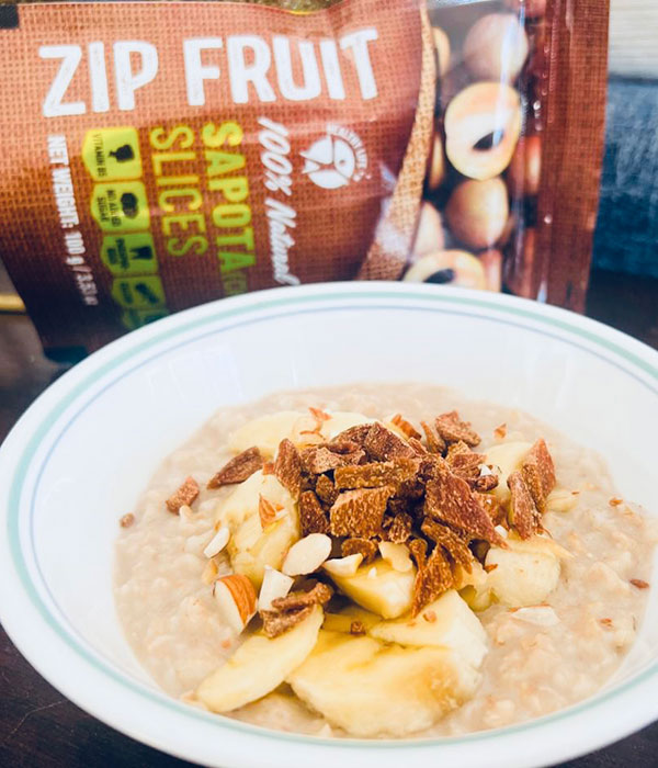 Banana Overnight Oats with Zip Fruit Sapota Powder in Bowl with Zip Fruit Packaging Vertical Photo