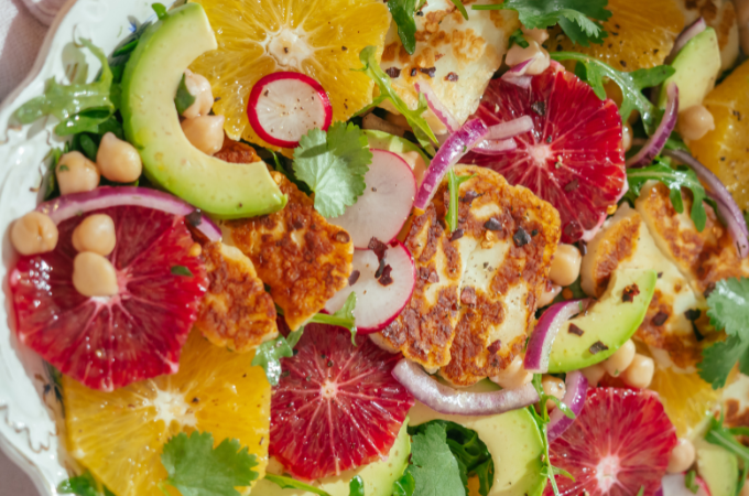 Halloumi cheese salad with fresh citrus in big white bowl