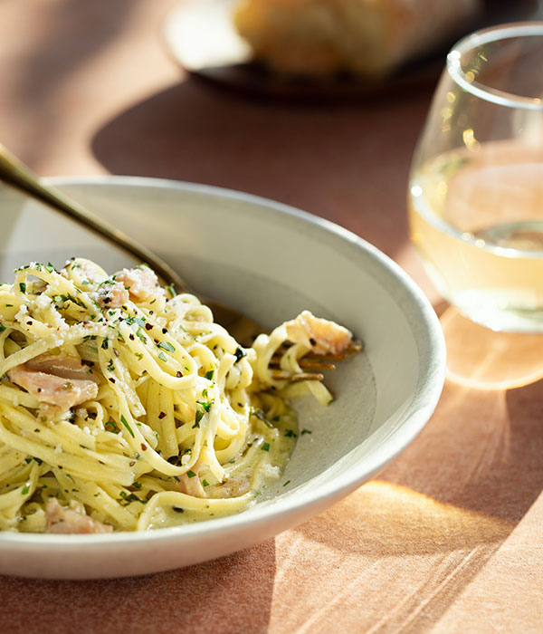 Classic Linguine and Clams in a Bowl with a Fork and Glass of White Wine