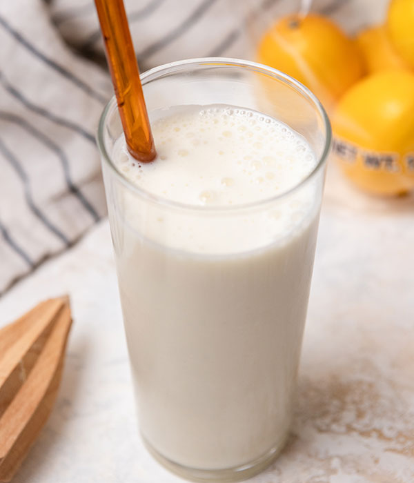 Copycat Frosted Lemonade with a Straw and Meyer Lemons in the Background