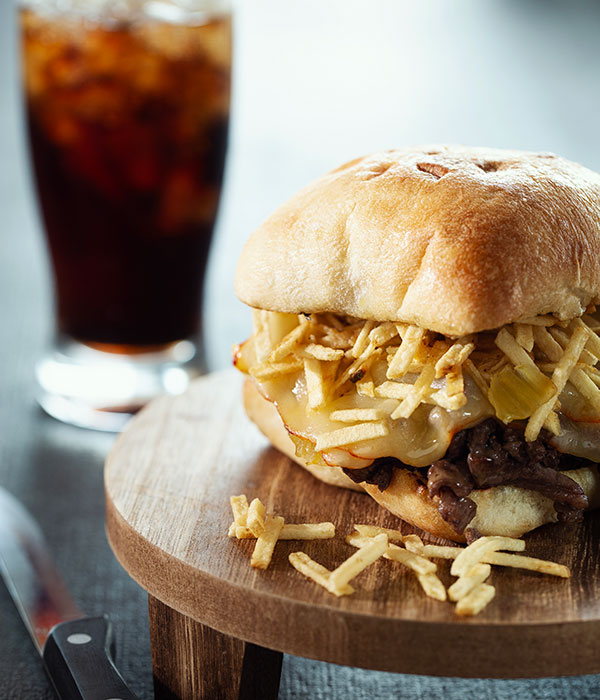 Steak Frites Sandwich on a Plate with a Glass of Cola and Ice