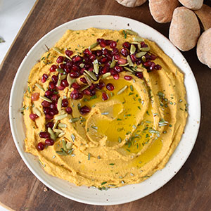 A Bowl of Creamy Pumpkin Hummus with Pomegranate Arils 