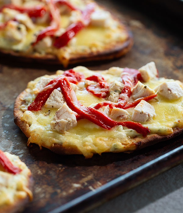 Close Up Vertical Image of Naan Chicken Faltbreads on a Baking Sheet