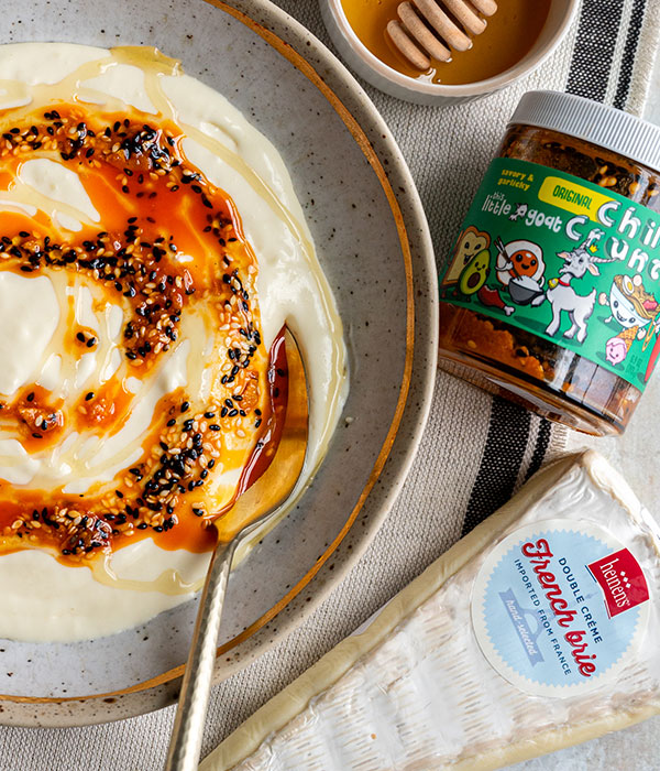 Sweet and Savory Whipped Brie in a Bowl with Chili Crunch and Chili Crunch and Brie Packaging Surrounding