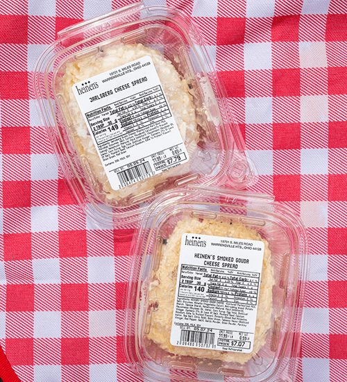 Two Containers of Heinen's Specialty Cheese Spreads on a Red and White Checkered Blanket