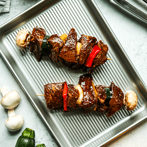 Heinen's Raw Black Pepper Marinated Beef Kabobs on a Metal Sheet Pan