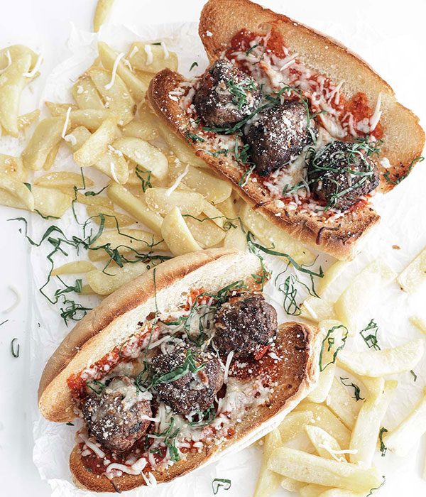 Meatball Subs on a White Surface with Golden French Fries