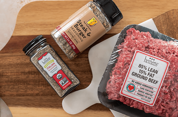Cutting board with steak & burger seasoning, Italian seasoning and Heinen's 85% lean ground beef.