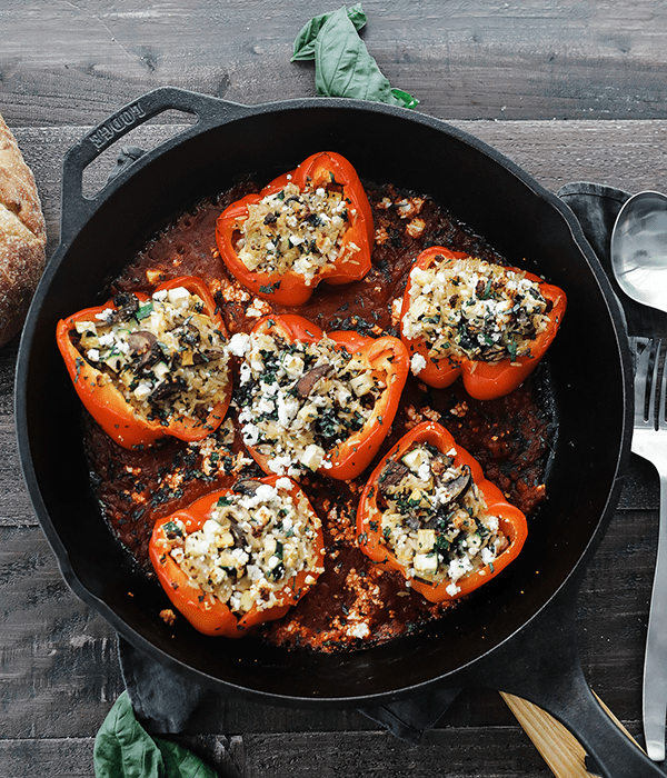 A Cast Iron Skillet Full of Grain and Veggie Stuffed Peppers