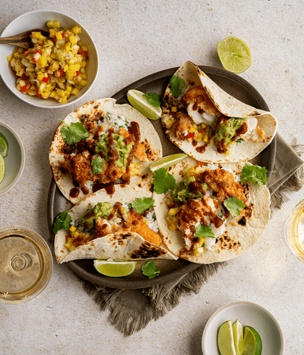 Four Parmesan Crusted Cod Tacos on a Serving Platter Beside a Bowl of Pineapple Mango Salsa