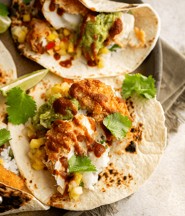 A Close Up Image of Two Parmesan Crusted Cod Tacos