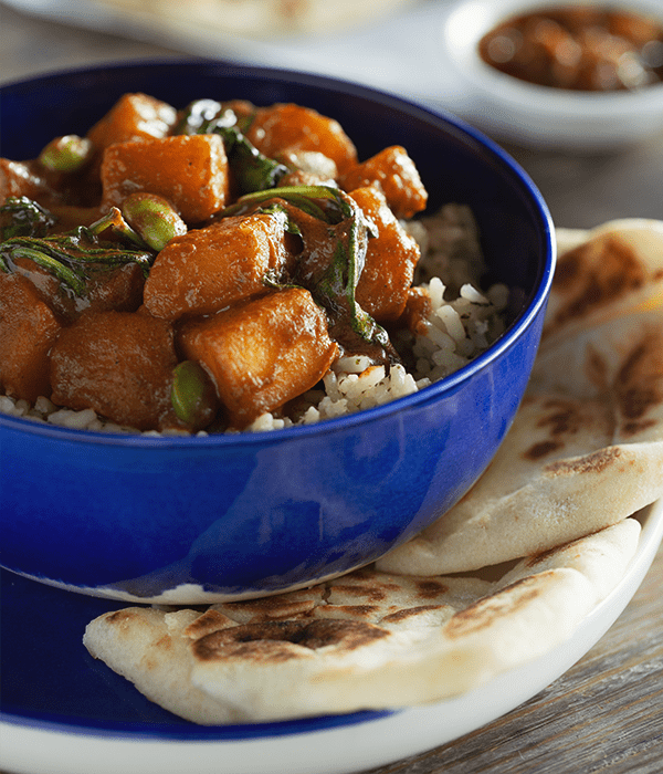 Butternut Squash Tikki Masala Bowl in a bowl with bread on the side