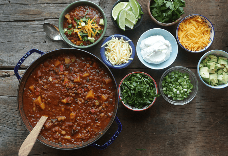 vegetarian chili in a pot surrounded by the ingredients