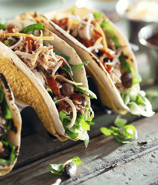 3 fully prepared tacos plated and ready to be eaten