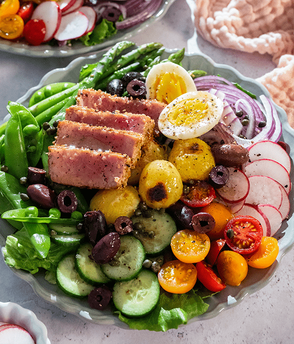 Sesame Crusted Ahi Tuna Nicoise Salad, plated with sides