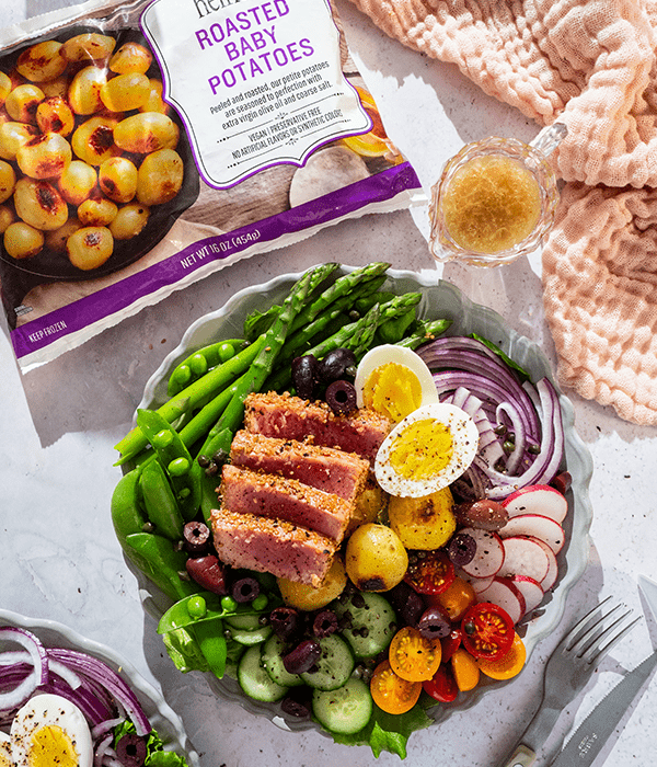 Sesame Crusted Ahi Tuna Nicoise Salad plated with a side of Heinen's potatoes