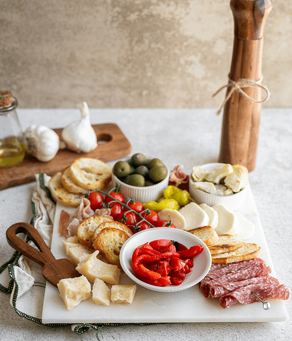 a fully plated Italian Antipasto Platter with a pepper grinder on the side of the dish