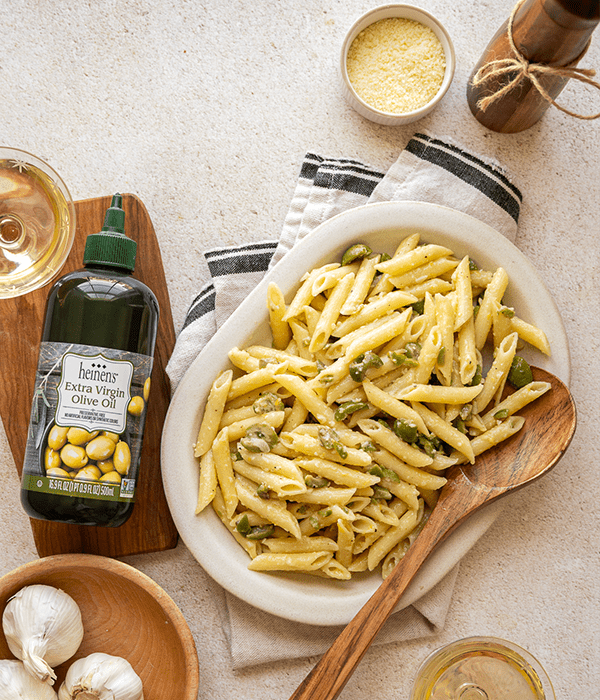 Green Olive Pasta plated sitting next to Heinen's olive oil