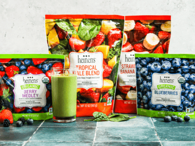 Heinen's Frozen Fruits standing up next to a green smoothie