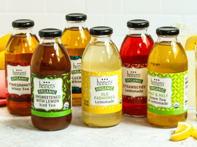 Heinen's Teas & Lemonades next to some glasses of the lemonade poured out with a lemon slice