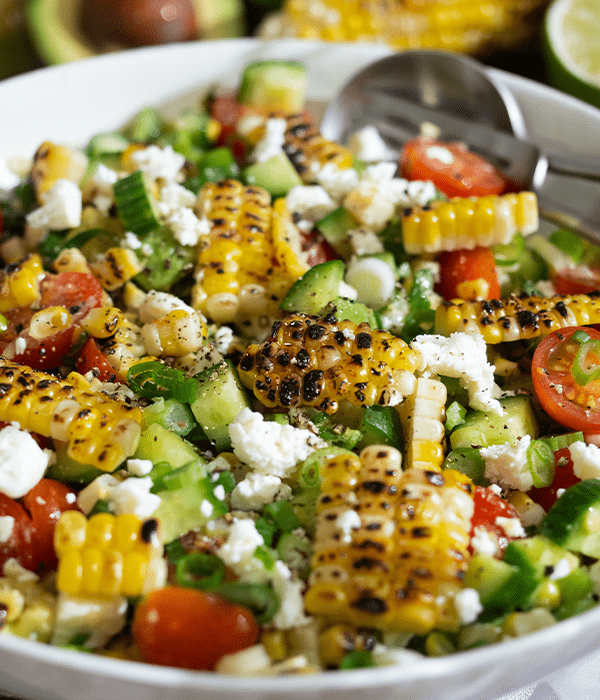 Avocado & Corn Salad in a bowl with a serving spoon