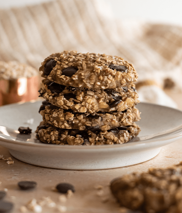 the Banana Oat Chocolate Chip Cookies stacked on top of each other on a white plate