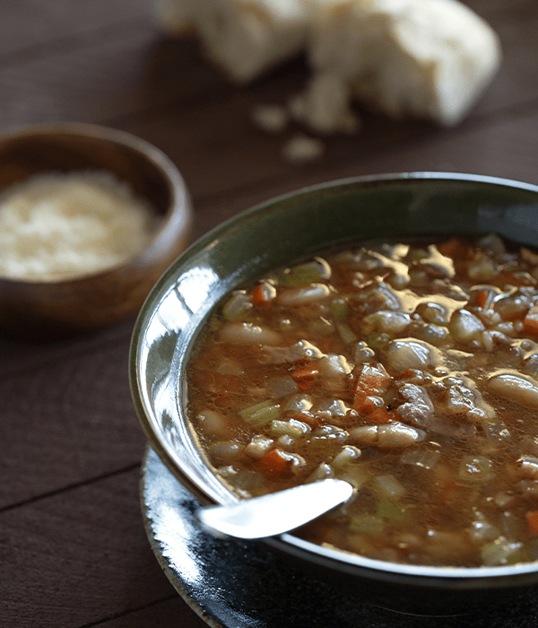 Easy Pasta Fagioli in a black bowl served with a side of bread and cheese