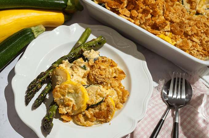 Southern Zucchini Squash Casserole plated with a side of asparagus