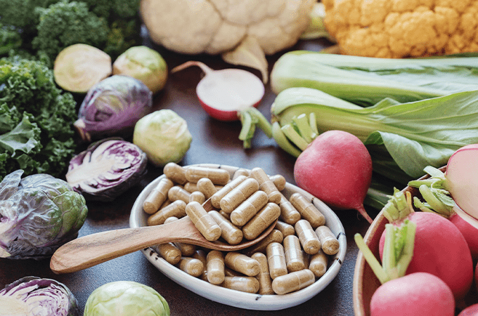 vegetables sitting by some health supplements