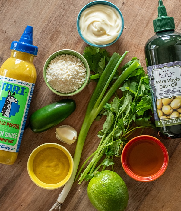 Ingredients on a wooden board for a peruvian aji verde sauce