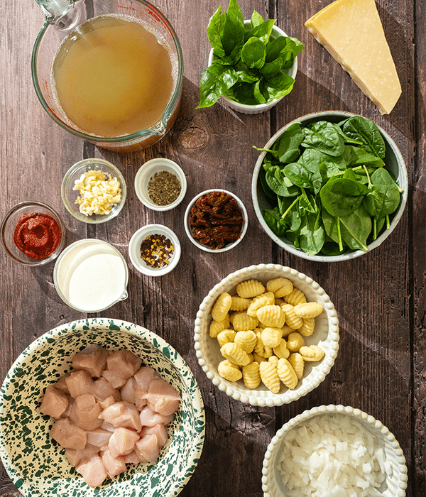 Marry Me Chicken Gnocchi Soup ingredients laid out on a wooden table