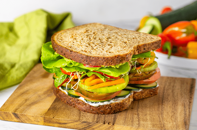 The California Veggie Sandwich freshly prepared and sitting on a wooden cutting board
