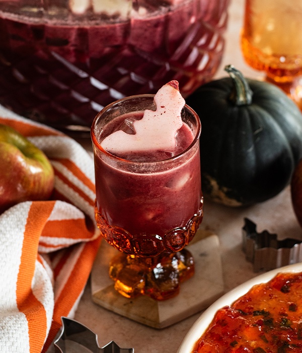 A glass of Halloween punch a bat-shaped apple garnish.