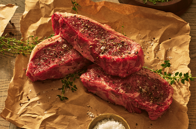 Heinen's Holiday strip steaks seasoned on butchers paper