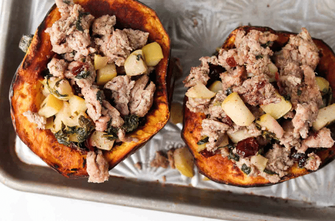 the Turkey and Kale Stuffed Acorn Squash cut in half and sitting in a sheet