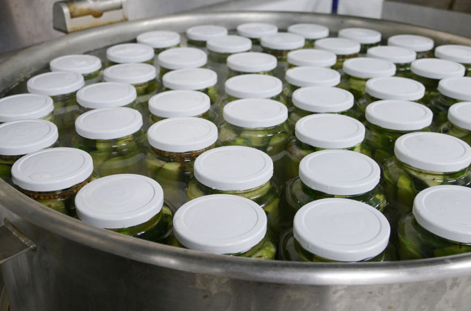 Pickles inside jars inside a large bowl