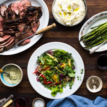 Lamb, mashed potatoes, asparagus, and a salad on a table