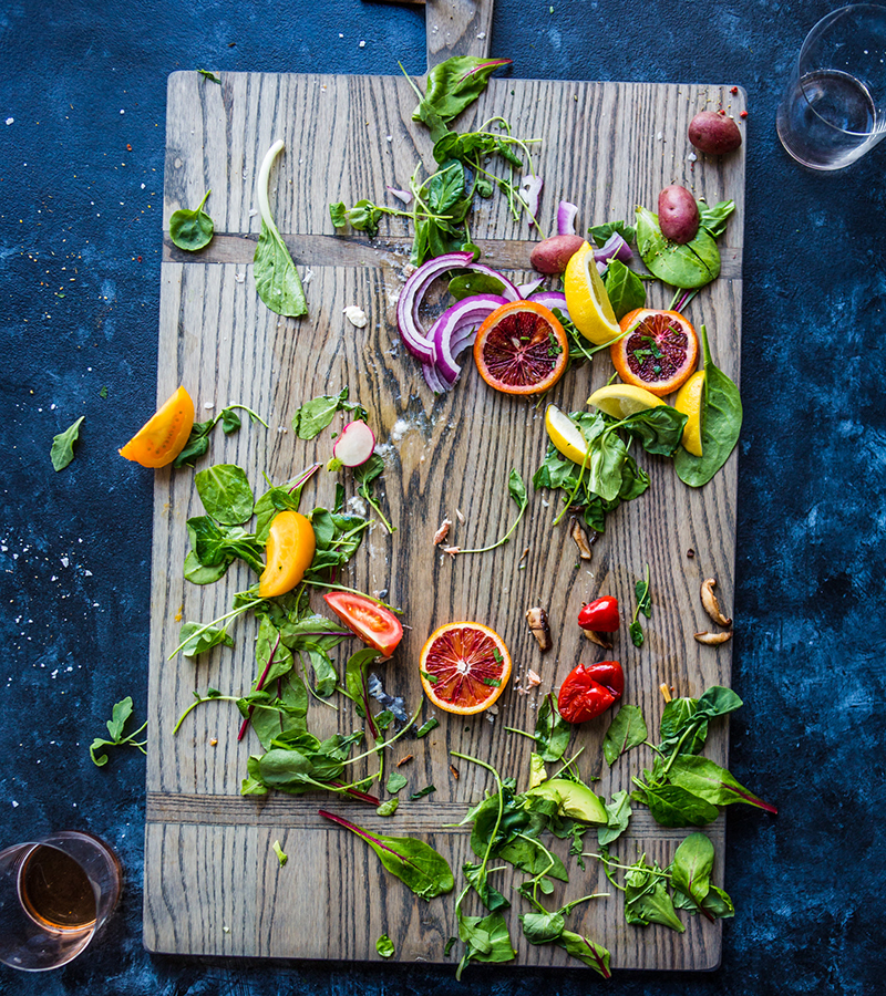 Wooden cutting board with herbs and citrus