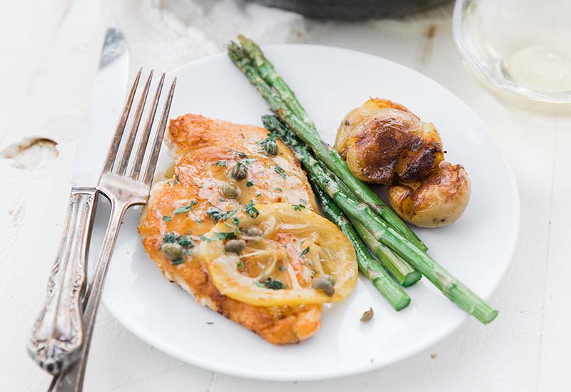 Chicken Piccata with Asparagus on a White Plate