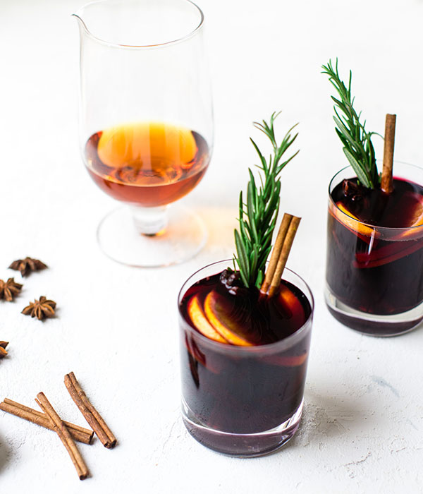 Mulled Wine in Two Glasses with Rosemary and Cinnamon