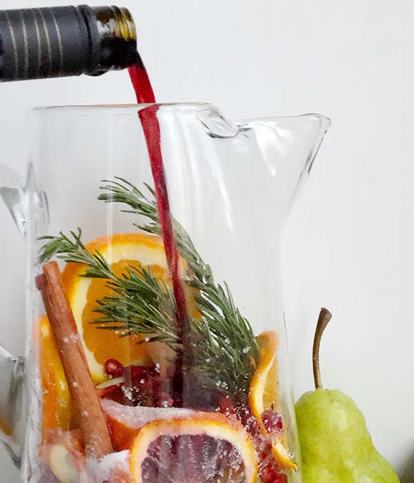 red wine pouring into the sangria pitcher
